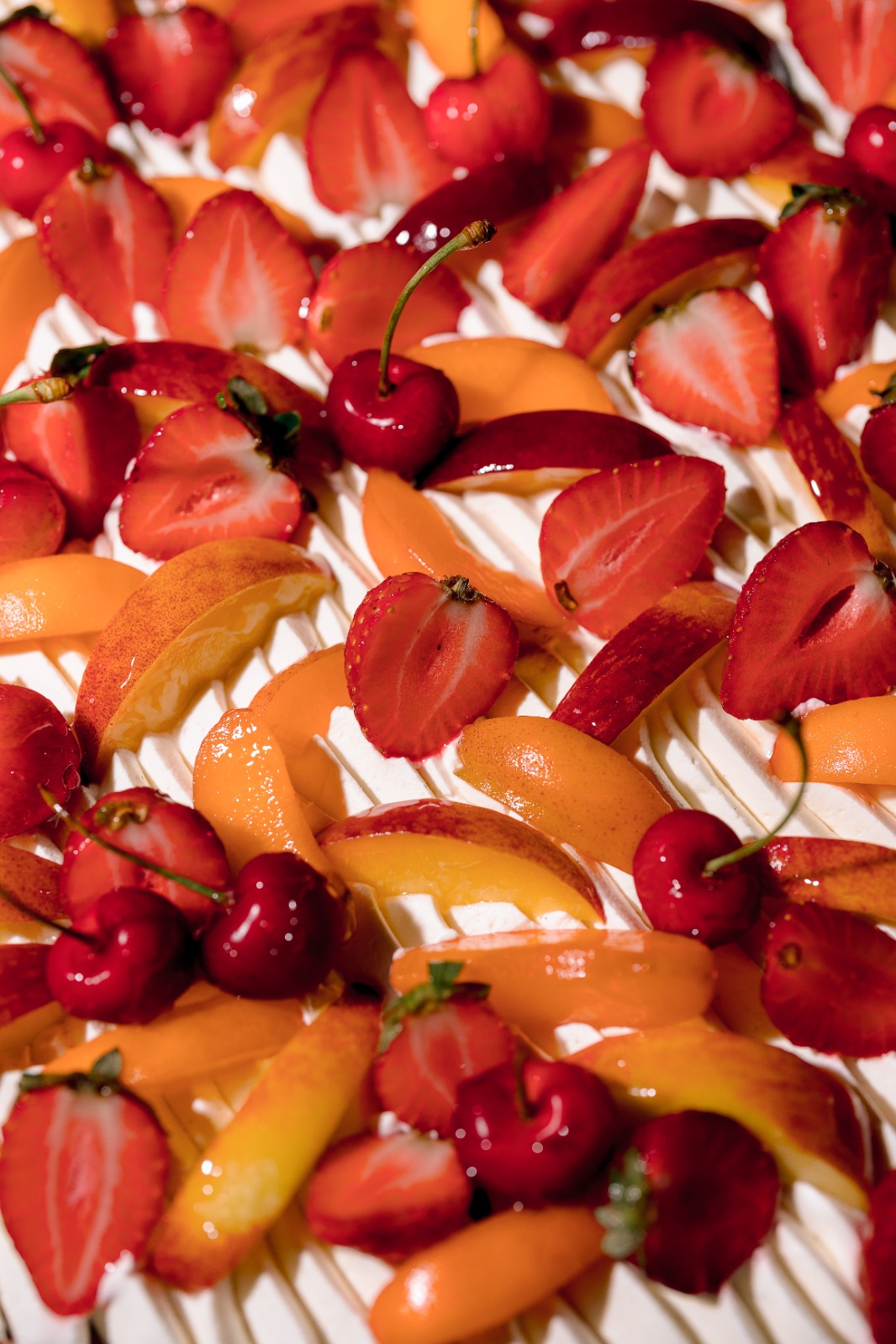 Cherries, strawberries and apricots on cream